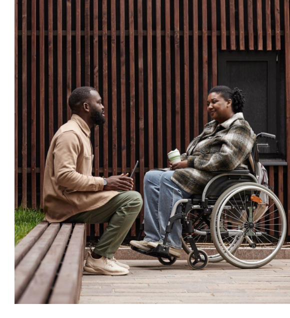 A man talking to a lady on a wheelchair